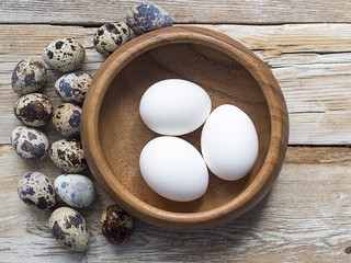 Chicken and quail eggs on a wooden table as easter background