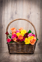 Fototapeta na wymiar Roses in the basket on wooden background