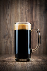 Glass of beer on wooden background