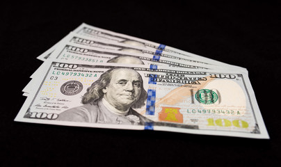 US one hundred dollars banknotes isolated on black background