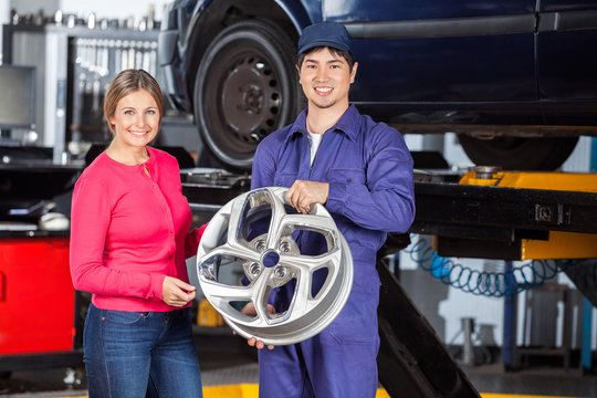 Happy Mechanic And Customer With Hubcap