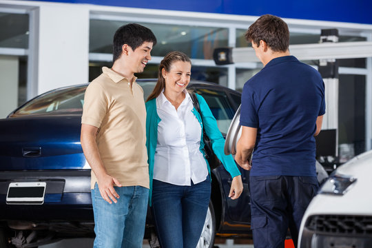 Couple Discussing Over Alloy With Mechanic