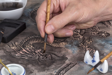 Artist painting a Chinese dragon