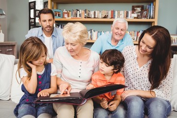 Smiling family with grandparents with photo album