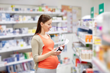 happy pregnant woman with medication at pharmacy