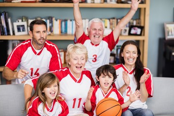 Cheerful family with grandparents watching basketball match