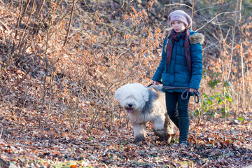 kind läuft mit einem hund durch den wald