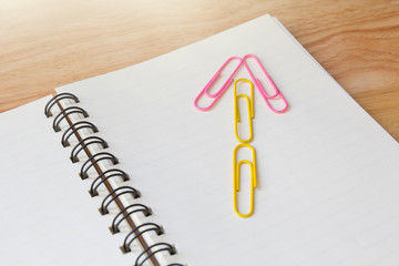 paper clips in shape of arrow on diary book
