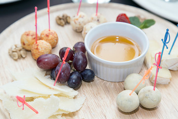 Different types of cheese balls, served with sauce and grapes on