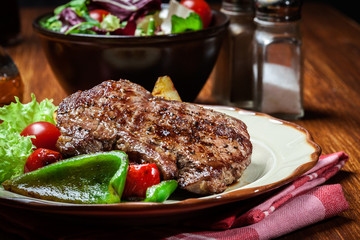 Portions of grilled beef steak with grilled potatoes and paprika