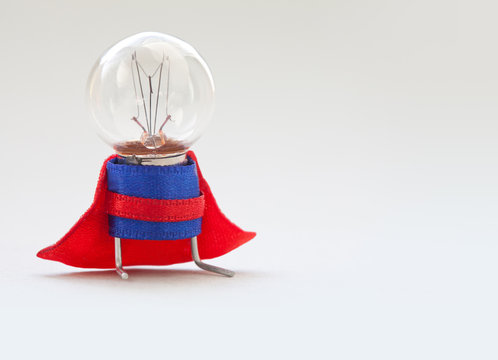 Light bulb lamp man in superhero costume. Vintage style lamp, stylized super hero character. Leadership and professional quality concept photography. Soft focus, light gradient background, copy space