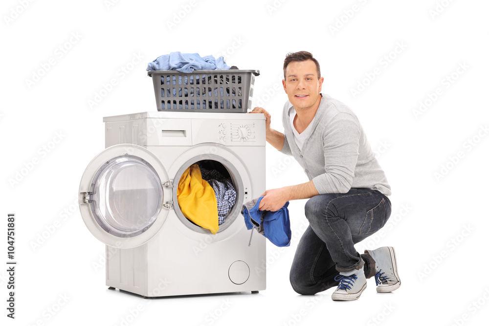 Wall mural Cheerful young man doing laundry