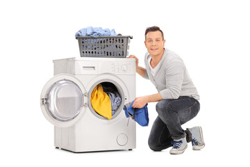 Cheerful young man doing laundry