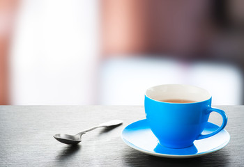 A cup of tea and a teaspoon