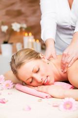 Obraz na płótnie Canvas Vertical photo of young beautiful woman enjoying massage at spa studio