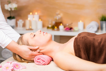 Obraz na płótnie Canvas Beautiful blonde woman getting facial massage at spa