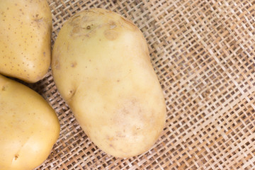 Raw potatoes on wooden background