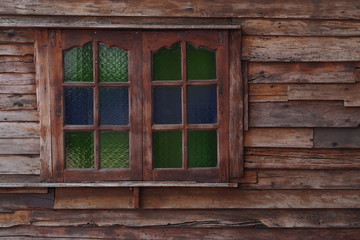 Old wooden house with colorful window 