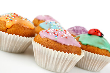 Colourful cupcakes with pastel coloured icing and sprinkles