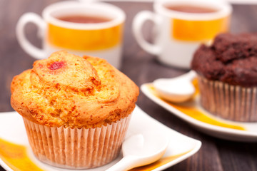 Cupcakes with tea on black wooden background
