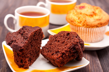 Cupcakes with tea on black wooden background