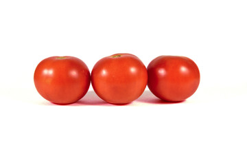 Three red tomatoes macro or close up isolated on white background