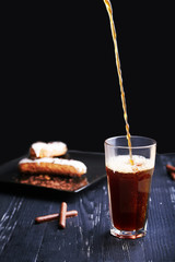 Pouring fresh coffee into a cup. Dark photo