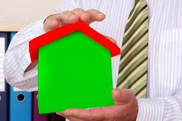 Businessman holding house