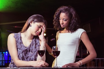 Woman having drinks and comforting her depressed friend