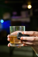 Woman holding a glass of whiskey and car keys