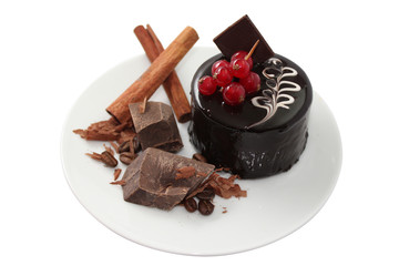 Cake with cinnamon and pieces of dark chocolate on white saucer