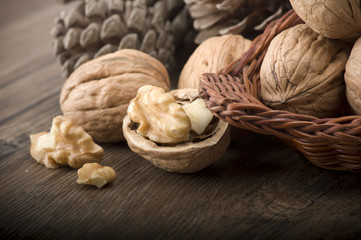 Walnut kernels and whole walnuts on rustic old wooden table