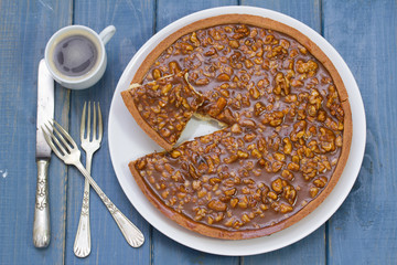tart with nuts and caramel on blue wooden background