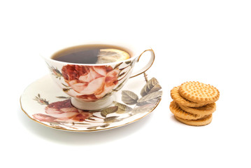 mug of tea with lemon and cookies on white