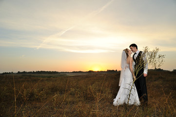 Bride and Groom in the Field at Sunset