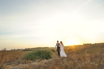 Bride and Groom in the Field at Sunset