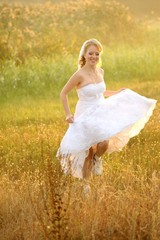 Fototapeta na wymiar Bride Posing in the Sunlit Field