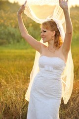 Fototapeta na wymiar Bride Posing in the Sunlit Field