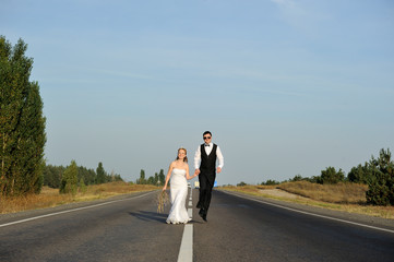 Just Married Couple Walking on the Paved Road