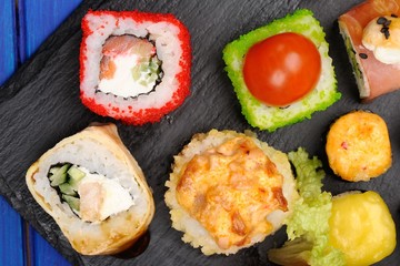Assorted japanese rolls on black board
