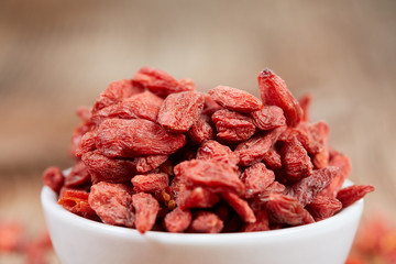Goji berries in a white china bowl on a table - 104768432
