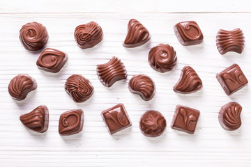 Delicious chocolate candies on wooden background