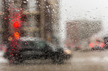 Road view through car window with rain drops and melting snow, Driving during snow storm in Montreal