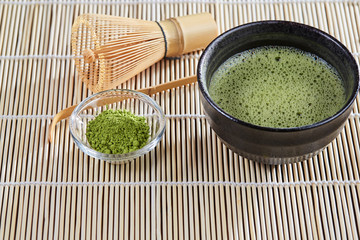 Green matcha tea preparation set on a bamboo table mat