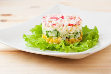 Salad of crab sticks on wooden countertop