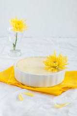 Obraz na płótnie Canvas Cheesecake in ceramic bowl with yellow flowers