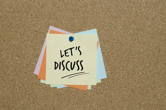 Let’s discuss message on paper note fixed on cork board