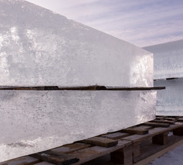 Clear blocks of ice piled on a wooden pallet