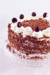 Black forest cake decorated with whipped cream and cherries. 