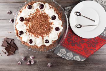 Black forest cake decorated with whipped cream and cherries. 